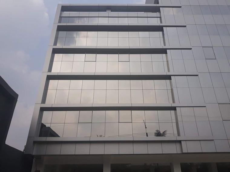 Hasil kerja CV Safari Makmur: fasad gedung bertingkat berpanel aluminium dan kaca