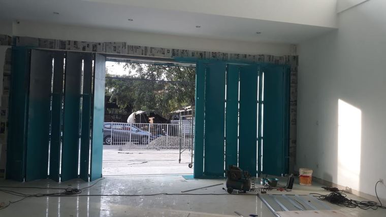 Hasil kerja CV Safari Makmur: pintu lipat besi berwarna hijau tosca di sebuah ruko